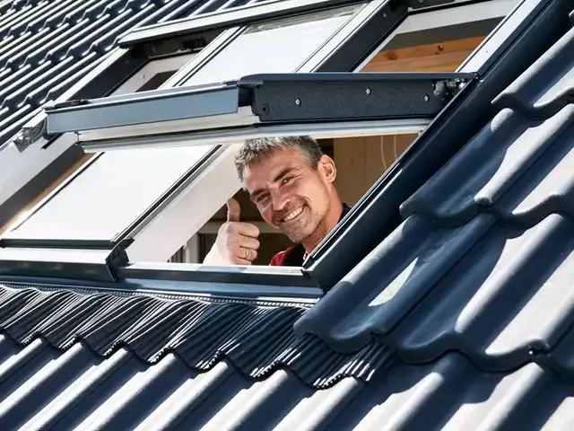Handwerker an einem eingebauten VELUX Dachfenster